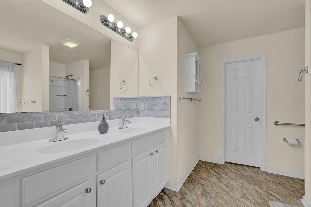 3160 Centerglen Lane Cumming, GA 30040 - Photo 32 of 40 a bathroom with double vanity sink and a mirror