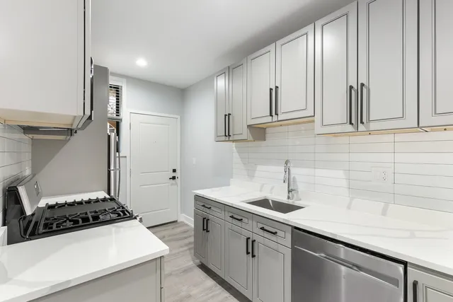 a kitchen with stainless steel appliances a sink a stove and a refrigerator