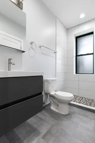 a bathroom with a toilet a sink and mirror