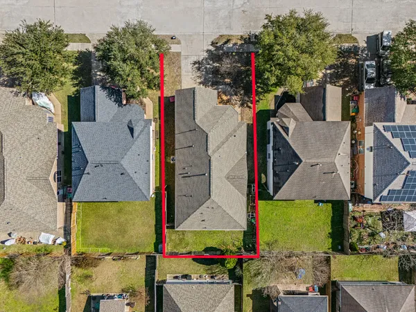an aerial view of residential houses with outdoor space and parking