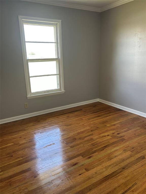 401 South Ave H Olney, TX 76374 - Photo 19 of 22 a view of an empty room with wooden floor and a window