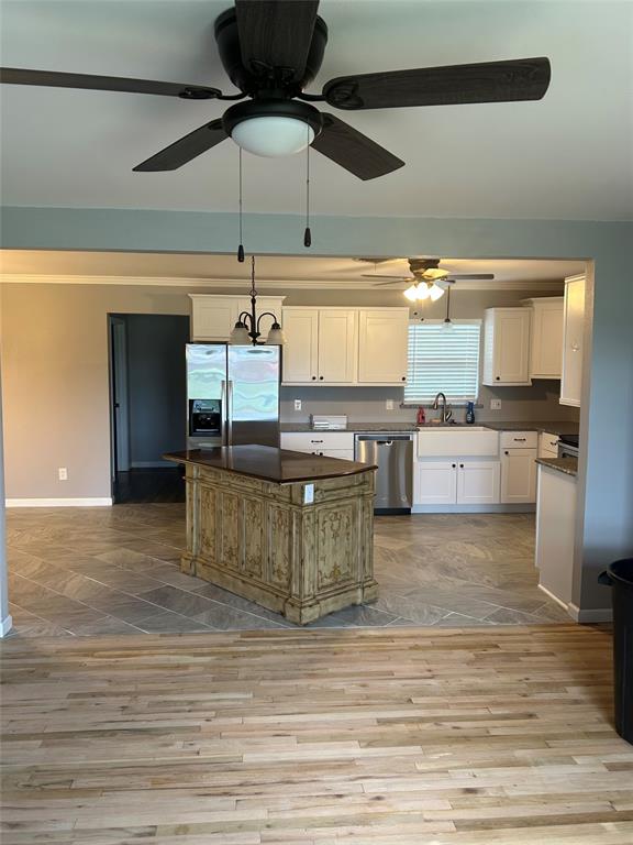 401 South Ave H Olney, TX 76374 - Photo 7 of 22 a kitchen with a stove cabinets and a wooden floor