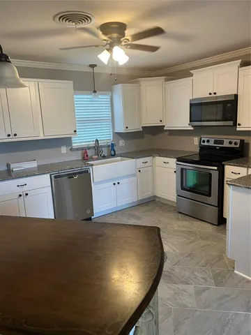 a kitchen with stainless steel appliances granite countertop a stove a sink a microwave and a refrigerator