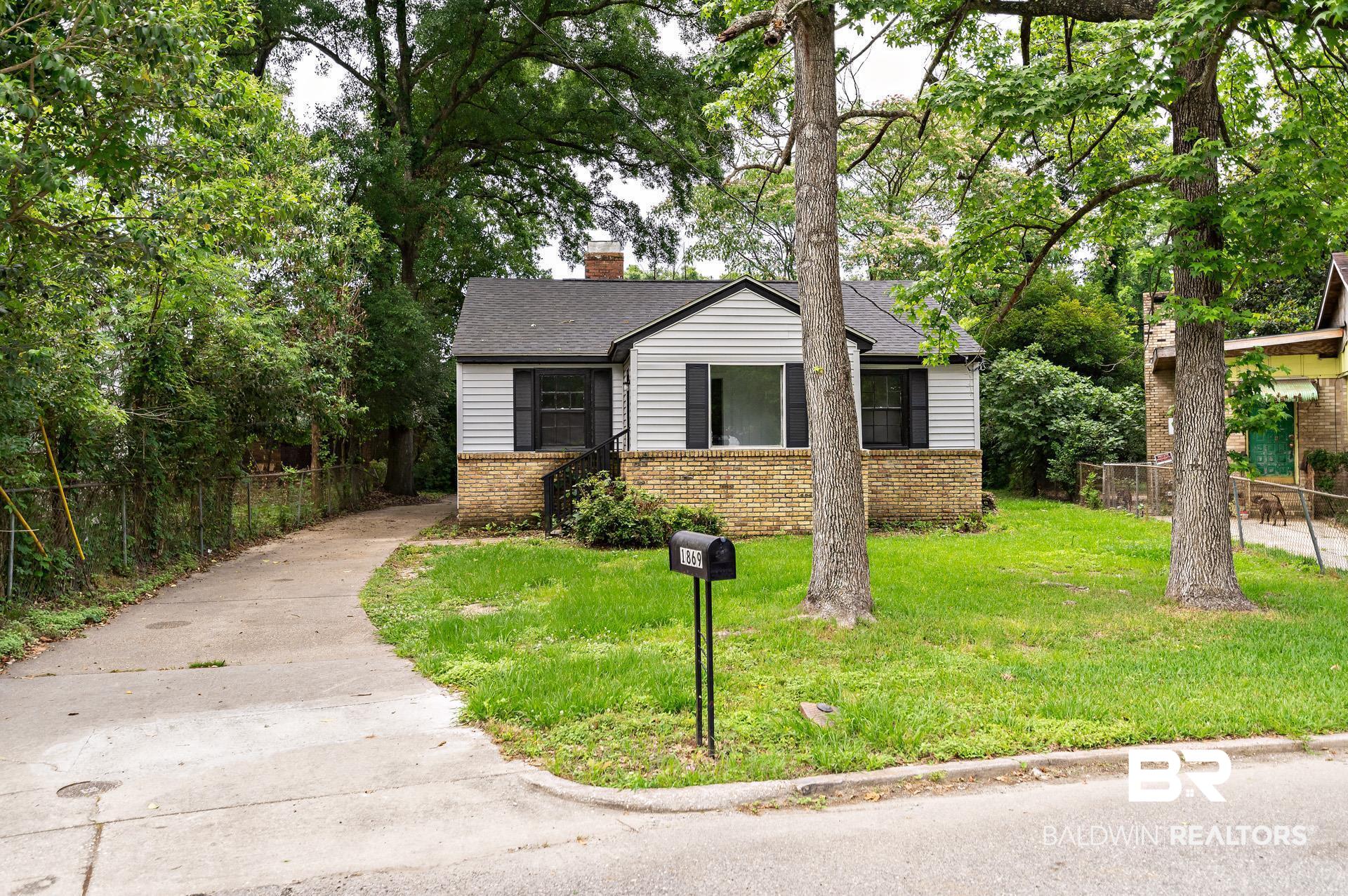1869 Mott Drive West Mobile, AL 36617 - Photo 2 of 34 View of front of home with fence, a chimney, a front yard, brick siding, and a shingled roof