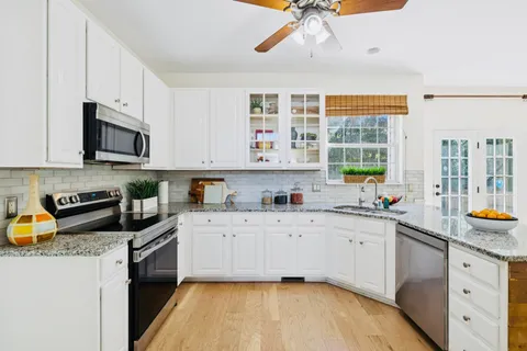 a kitchen with stainless steel appliances granite countertop a sink a stove and cabinets