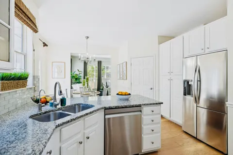 a kitchen with stainless steel appliances granite countertop a sink stove and refrigerator