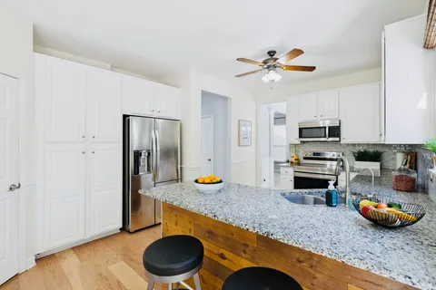 a kitchen with stainless steel appliances granite countertop a sink a stove and a refrigerator