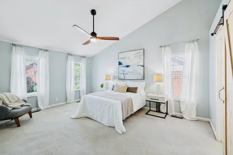 a spacious bedroom with a bed couch and a window