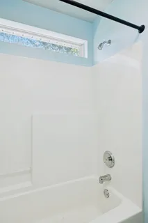 an empty room with a window and a ceiling fan