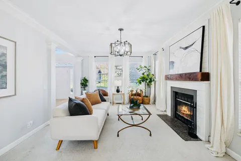 a living room with furniture a fireplace and a chandelier