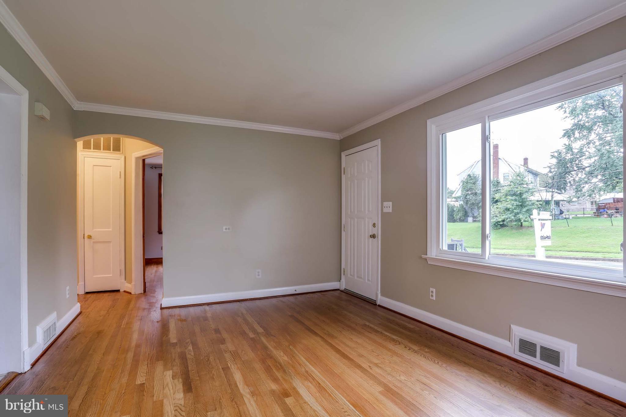 1254 June Road Baltimore, MD 21227 - Photo 8 of 23 a view of an empty room with wooden floor and a window