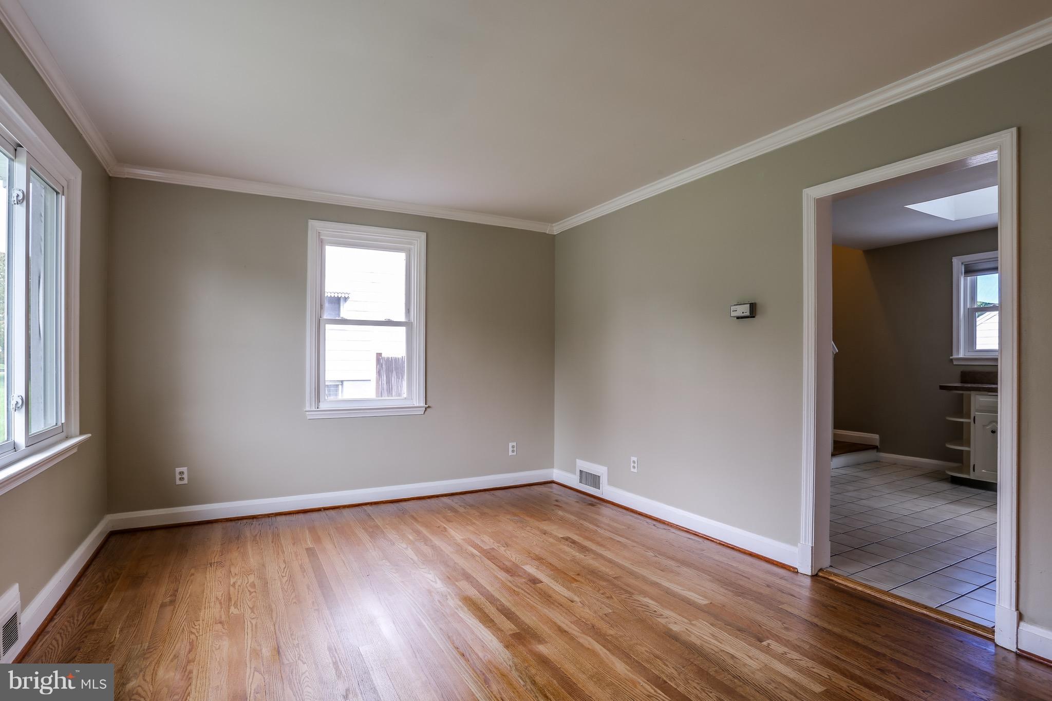 1254 June Road Baltimore, MD 21227 - Photo 9 of 23 an empty room with wooden floor and windows