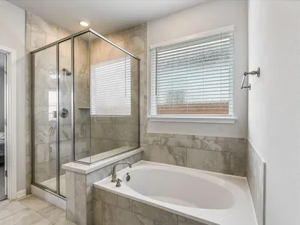 a spacious bathroom with a tub sink and mirror