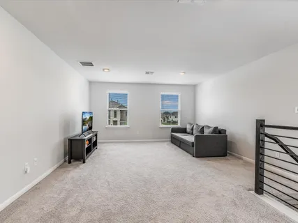 a view of an empty room with furniture and a flat screen tv