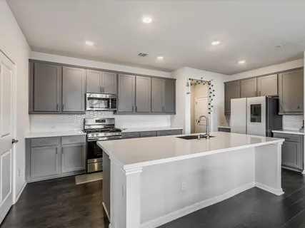 a kitchen with stainless steel appliances a refrigerator sink and microwave