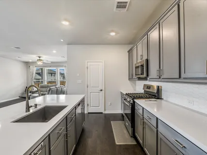 a view of a big house with a big yard potted plants and large trees