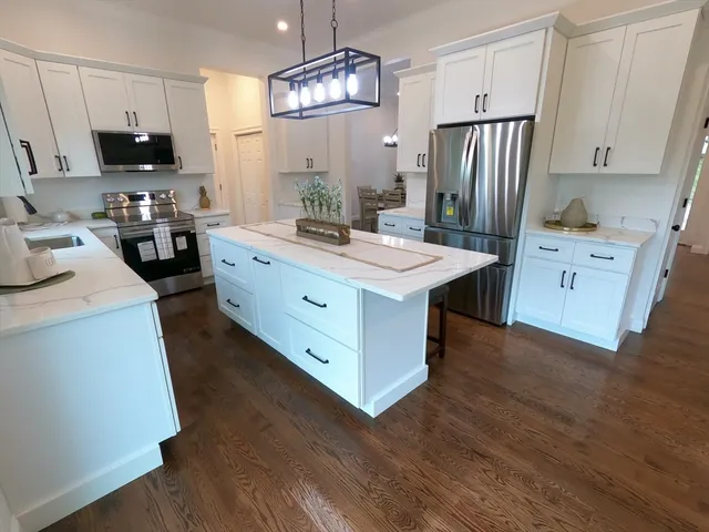 a kitchen with stainless steel appliances a stove refrigerator and microwave