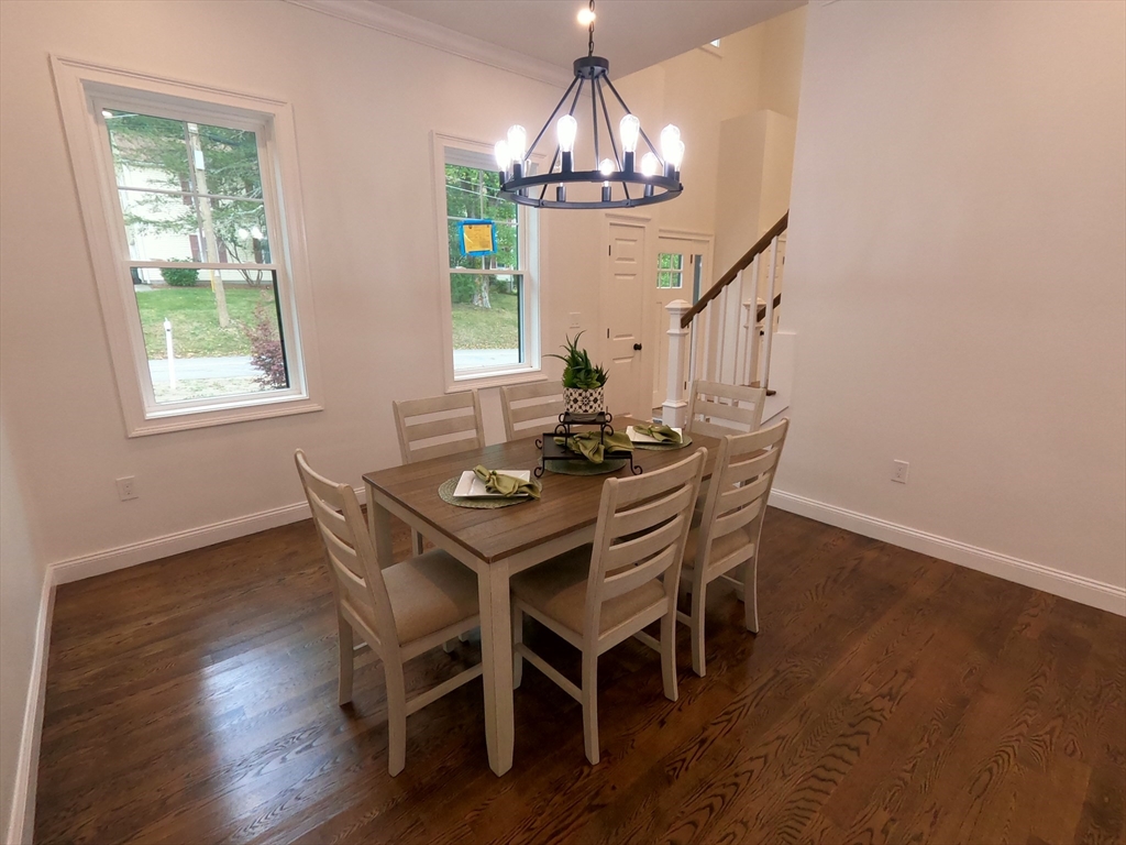 86 Berry Corner Road Charlton, MA 01507 - Photo 16 of 41 a dining room with wooden floor a chandelier a wooden table and chairs