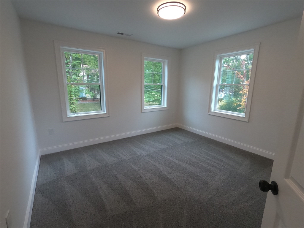 86 Berry Corner Road Charlton, MA 01507 - Photo 23 of 41 a view of an empty room with wooden floor and windows