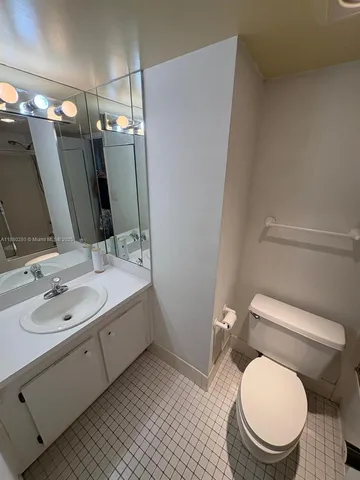 a bathroom with a granite countertop toilet sink and mirror