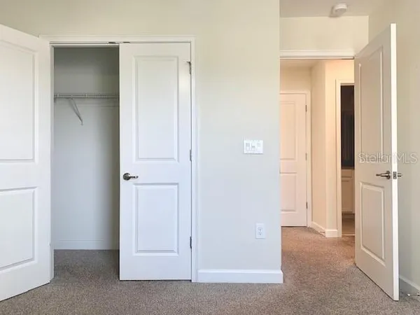a view of an empty room with closet area