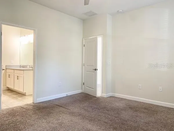 an empty room with windows and entrance to other room