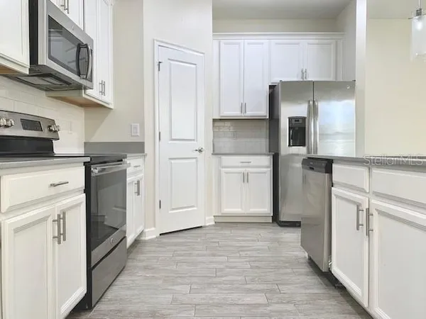 a kitchen with cabinets and stainless steel appliances