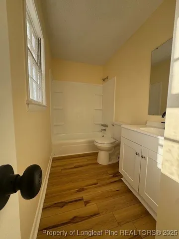 an empty room with windows and ceiling fan