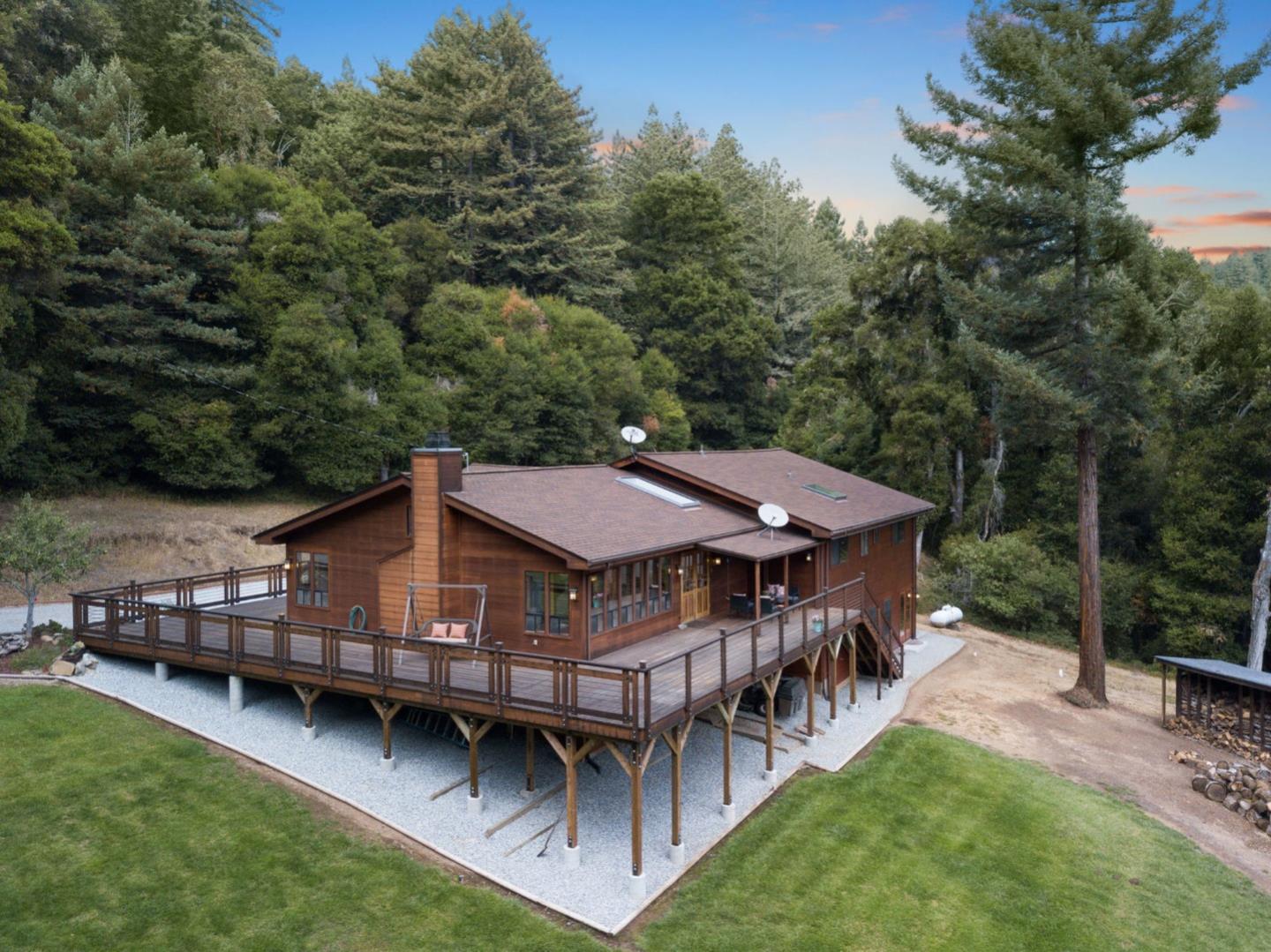 a view of a house with wooden deck and furniture