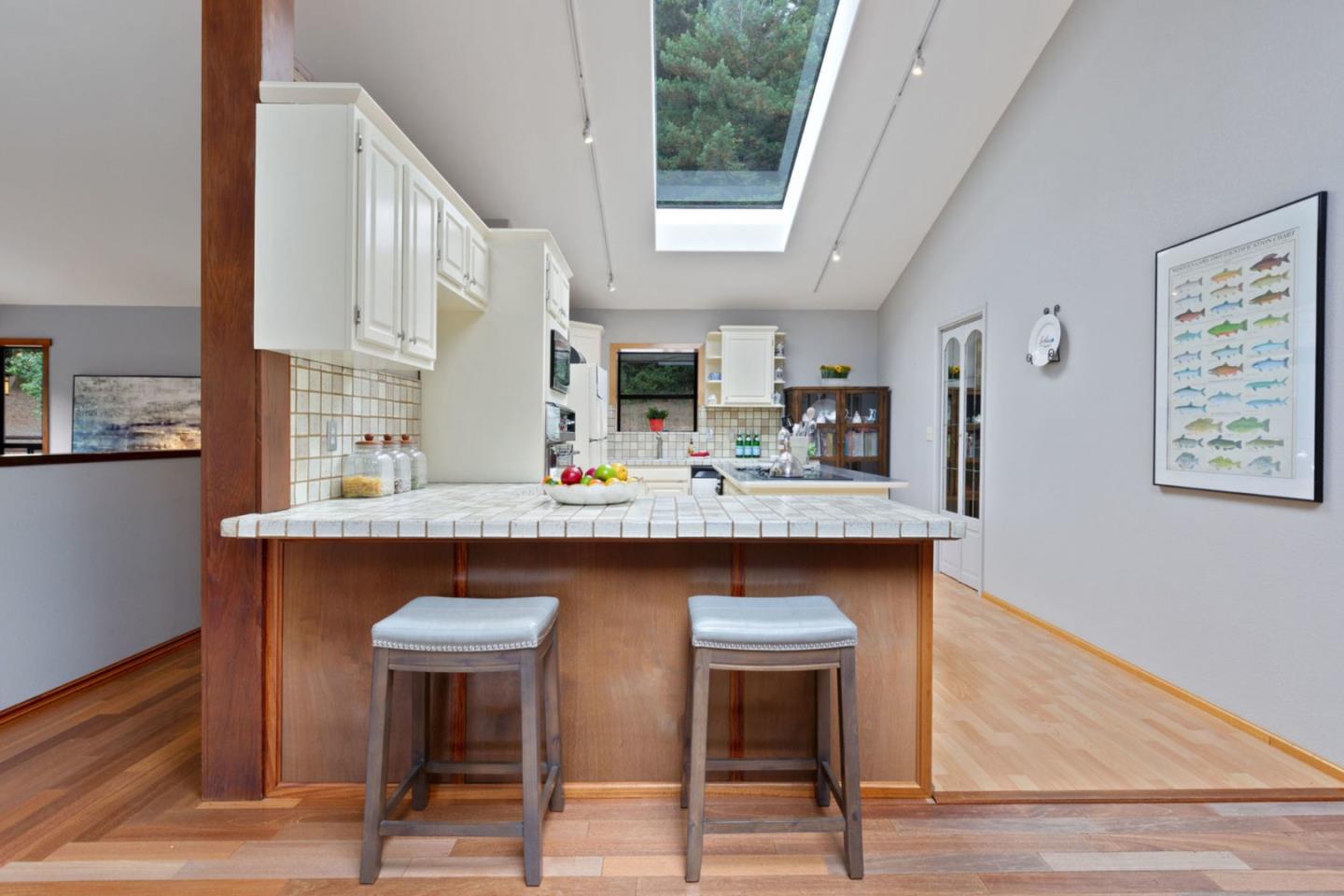 2060 Sparrow Valley Road Aptos, CA 95003 - Photo 11 of 45 a kitchen with stainless steel appliances granite countertop a table chairs in it and wooden floors