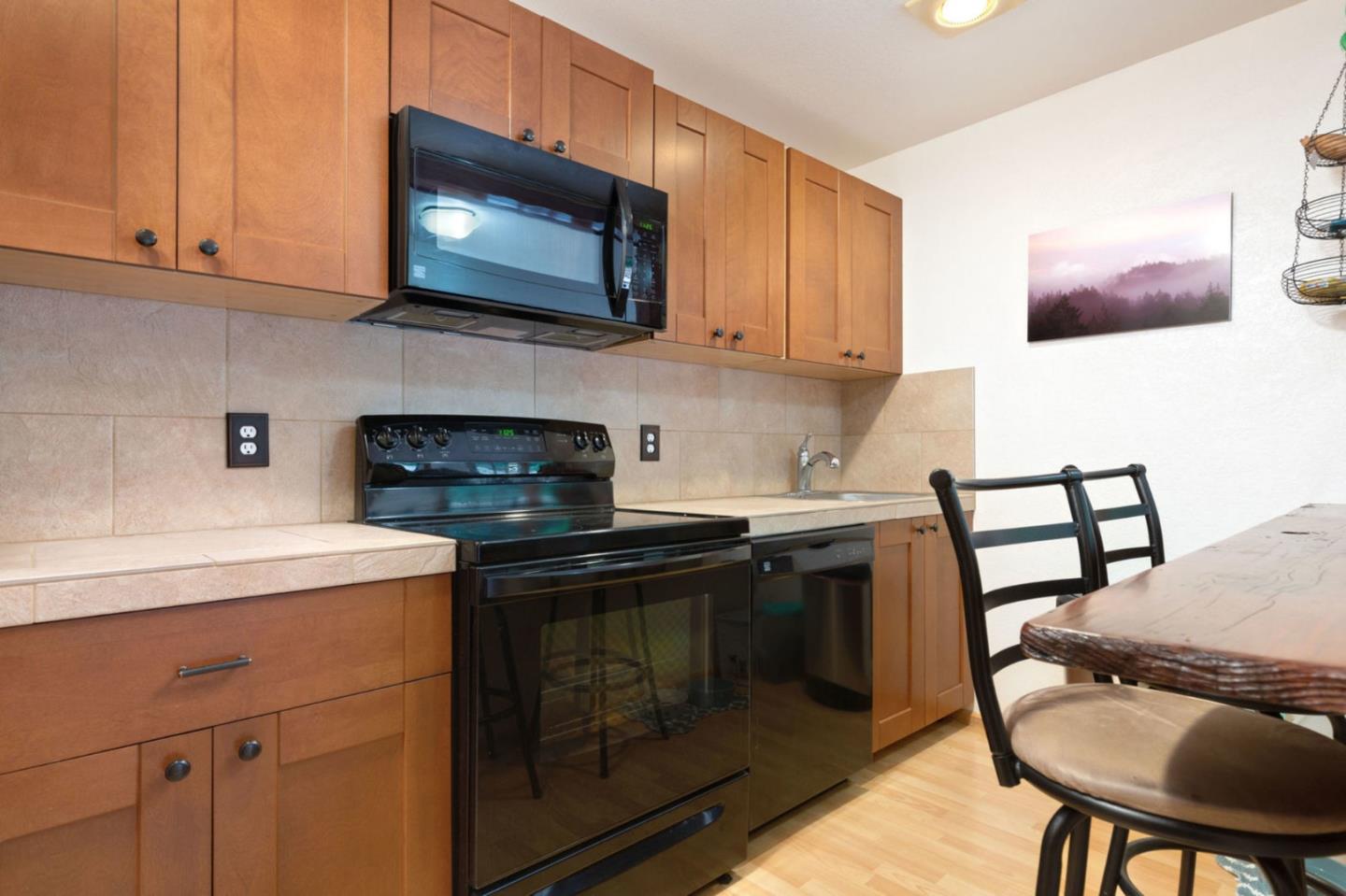 2060 Sparrow Valley Road Aptos, CA 95003 - Photo 26 of 45 a kitchen with stainless steel appliances kitchen island granite countertop a stove a sink and a microwave