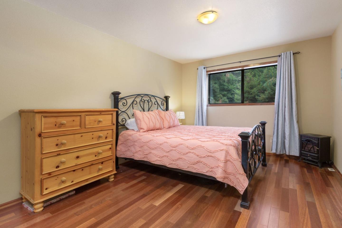 2060 Sparrow Valley Road Aptos, CA 95003 - Photo 27 of 45 a bedroom with a bed and a dresser next to a window
