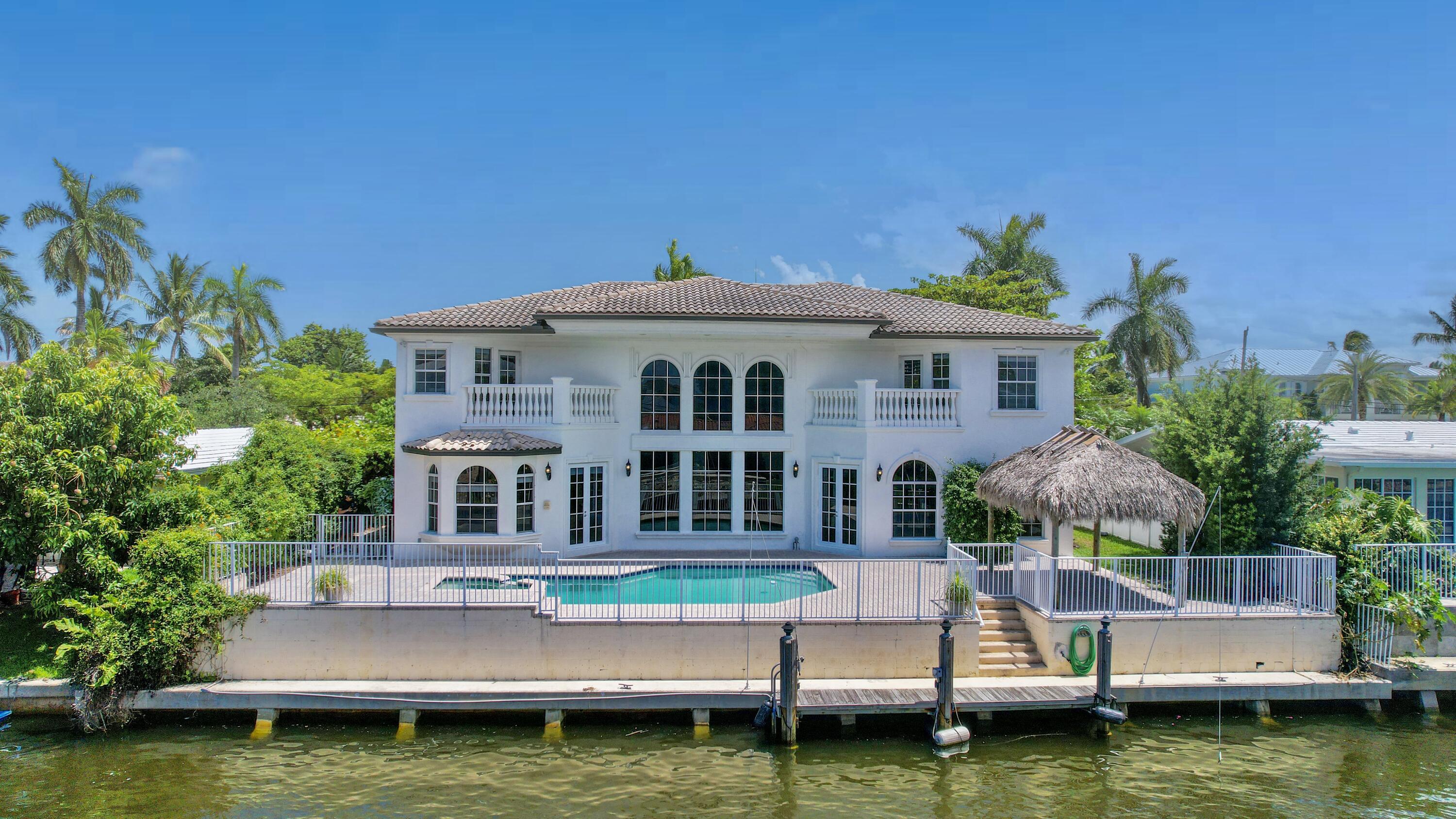 a front view of a house with a garden and swimming pool