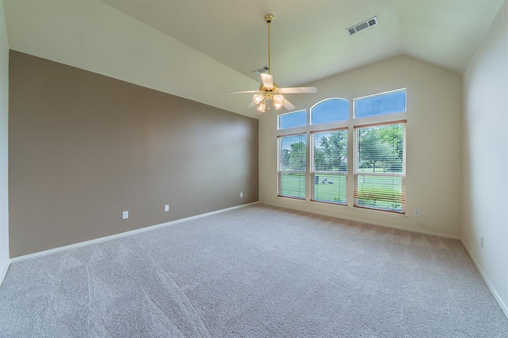 7517 Rodeo Drive Denton, TX 76208 - Photo 22 of 39 The very large primary bedroom features a wall of windows, ceiling fan, and privacy blinds.