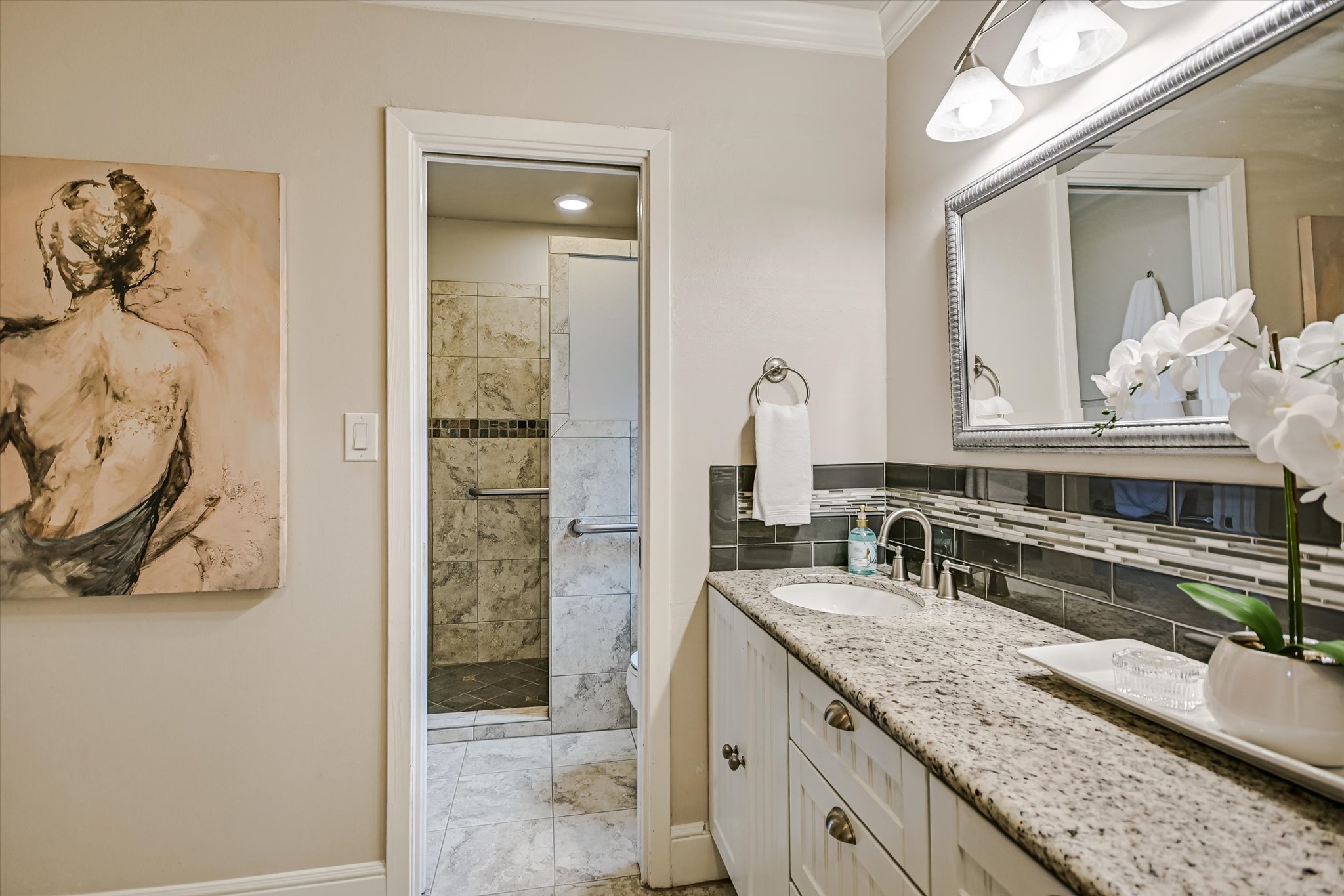 8602 Silver Ridge Drive Austin, TX 78759 - Photo 17 of 40 The primary bath, updated in 2013, showcases granite countertops, decorative tile, updated lighting and mirror, a walk-in shower, and a separate tub and private water closet.