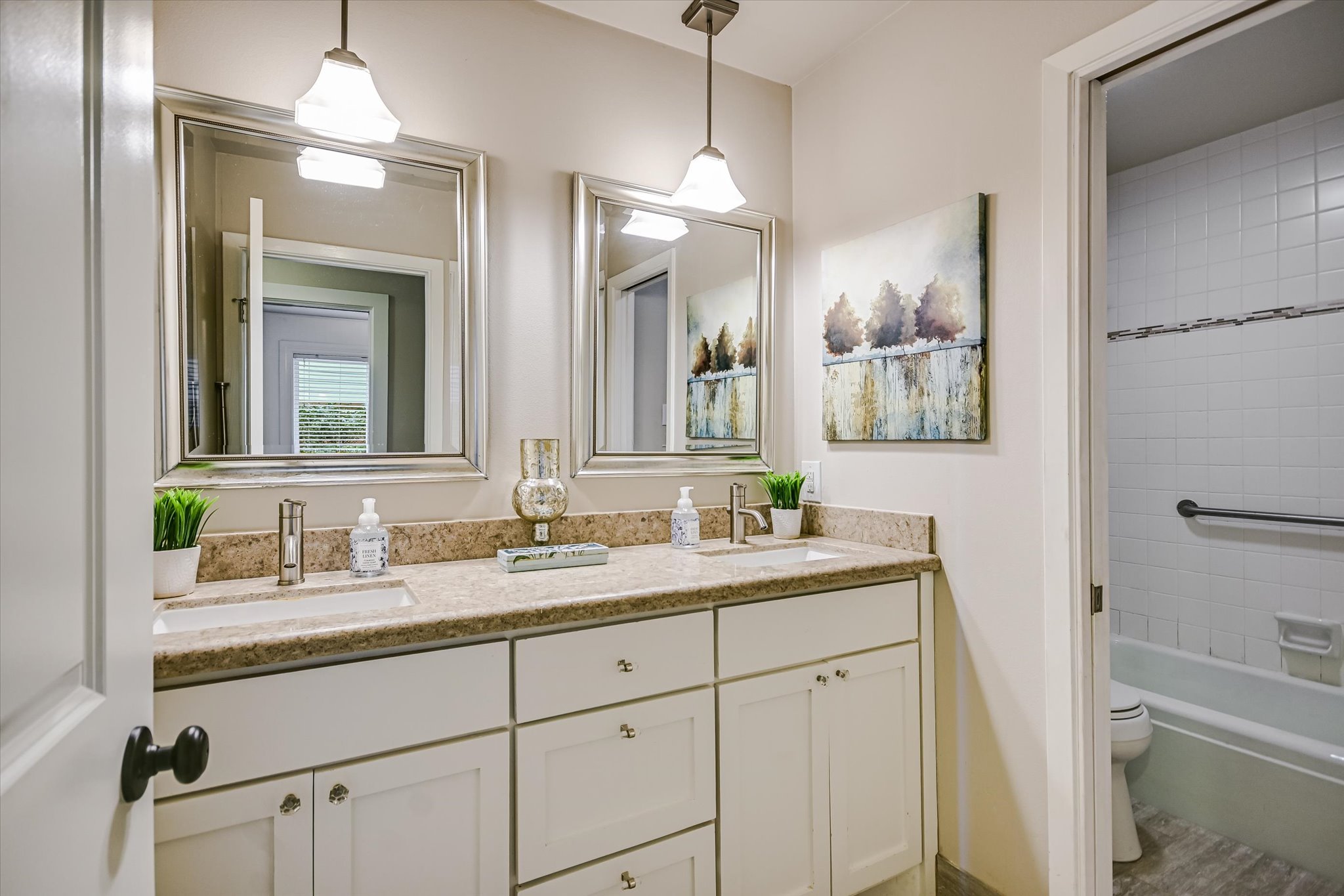 8602 Silver Ridge Drive Austin, TX 78759 - Photo 22 of 40 The secondary bath offers dual sinks, granite countertops, and a separate tub and toilet area for added functionality.