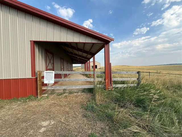 a view of a terrace with a barbeque and wooden fence