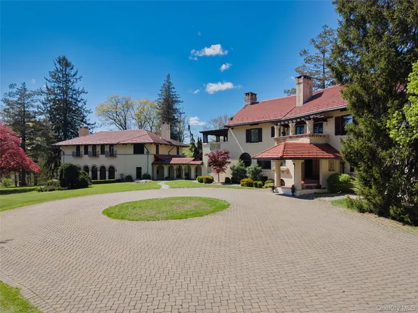 a front view of a house with yard and trees