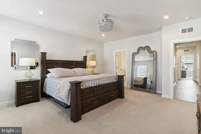 a spacious bedroom with a bed and lamp