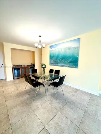 a living room with patio furniture and a dining table