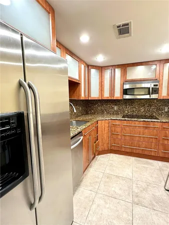 a kitchen with stainless steel appliances kitchen island granite countertop a stove a sink and a microwave