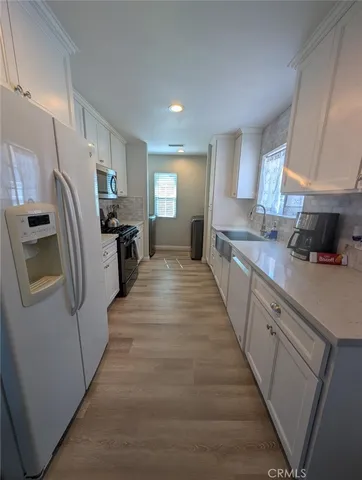 a large kitchen with a sink and refrigerator