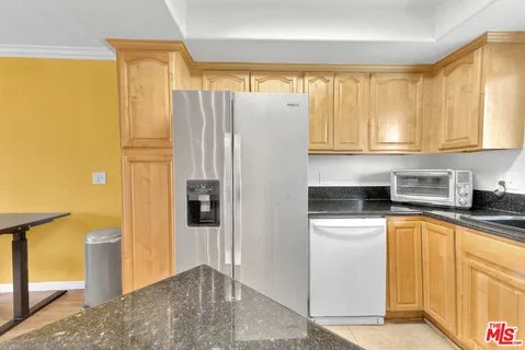 a kitchen with stainless steel appliances granite countertop a refrigerator and a stove