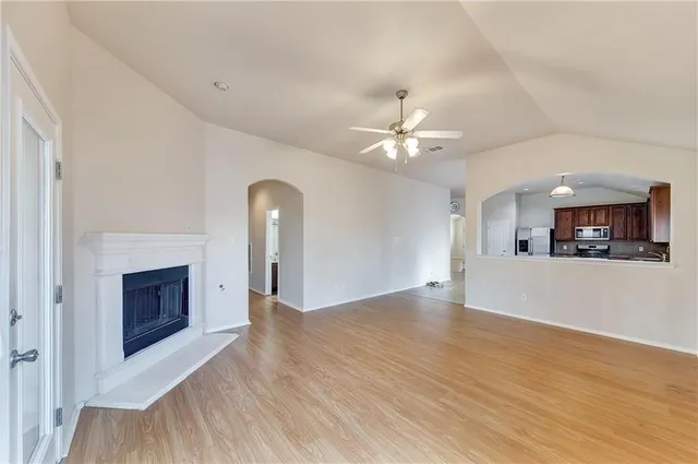 a view of a livingroom with a fireplace a chandelier and wooden floor