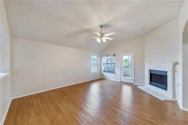 a view of an empty room with a fireplace and a window