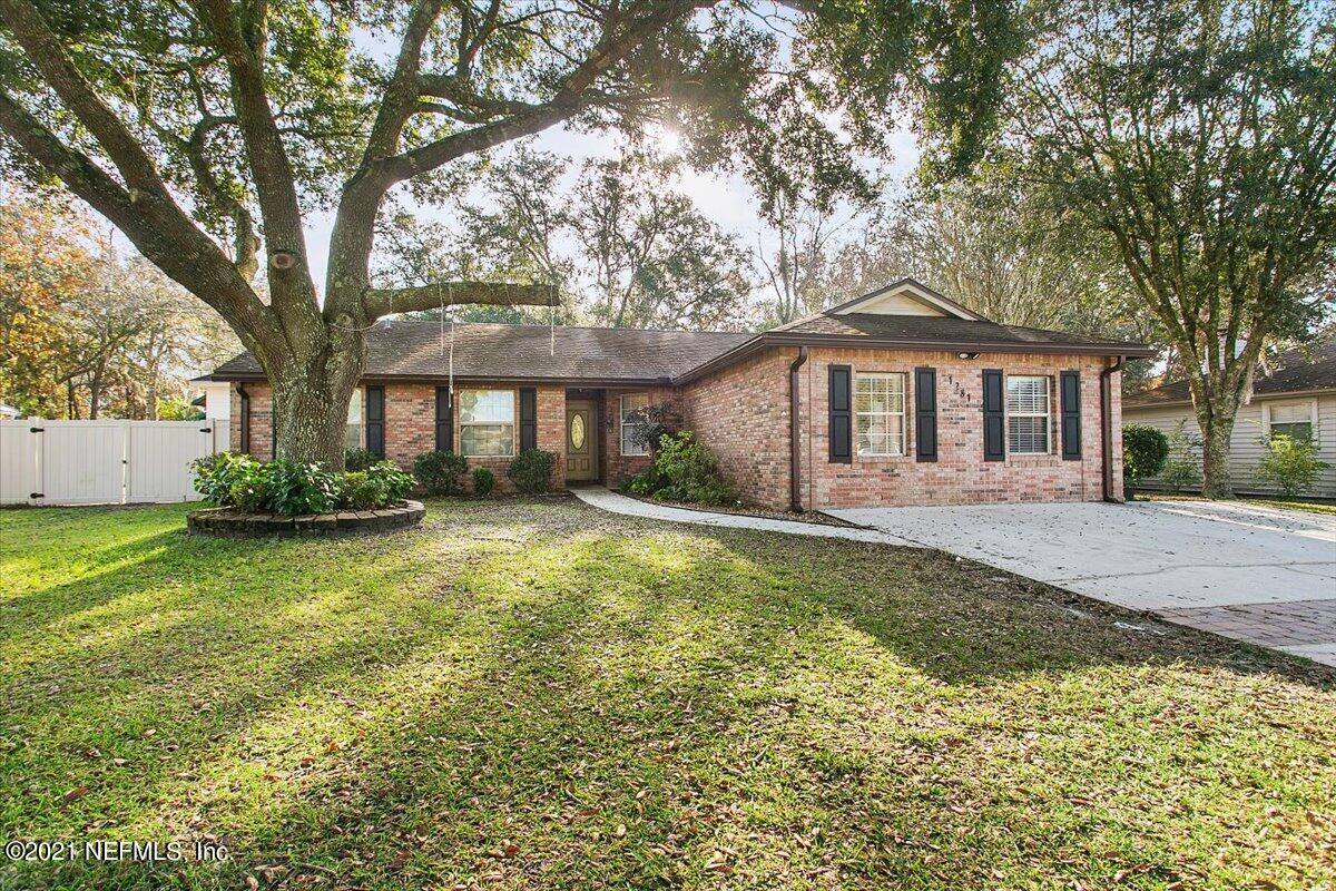 1281 Cutlass Road Orange Park, FL 32065 - Photo 1 of 21 a front view of a house with a garden and trees