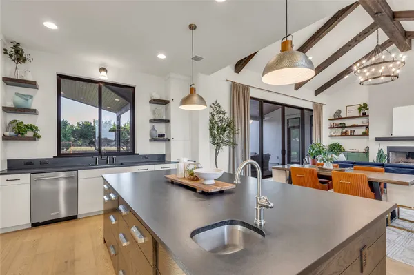 a kitchen with granite countertop a sink a counter space cabinets and stainless steel appliances