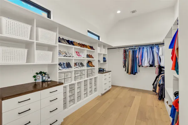 a hallway with white cabinets and window