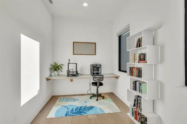 a view of a workspace with furniture and window