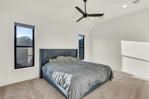 a bedroom with a bed and a refrigerator